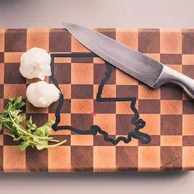 An end grain checkerboard cutting board with a state outline filled in dark epoxy.