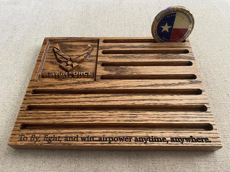 Small wooden Air Force coin holder with horizontal slots and a coin standing upright at the back