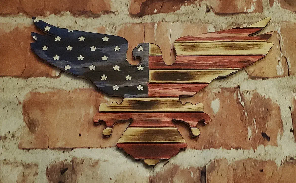 Carved American flag with a blue star field and red-and-natural stripes forming an eagle silhouette