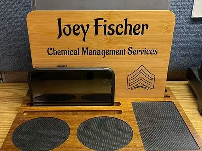 Finished bamboo desk organizer with an upright personalized panel and black circular and rectangular liners