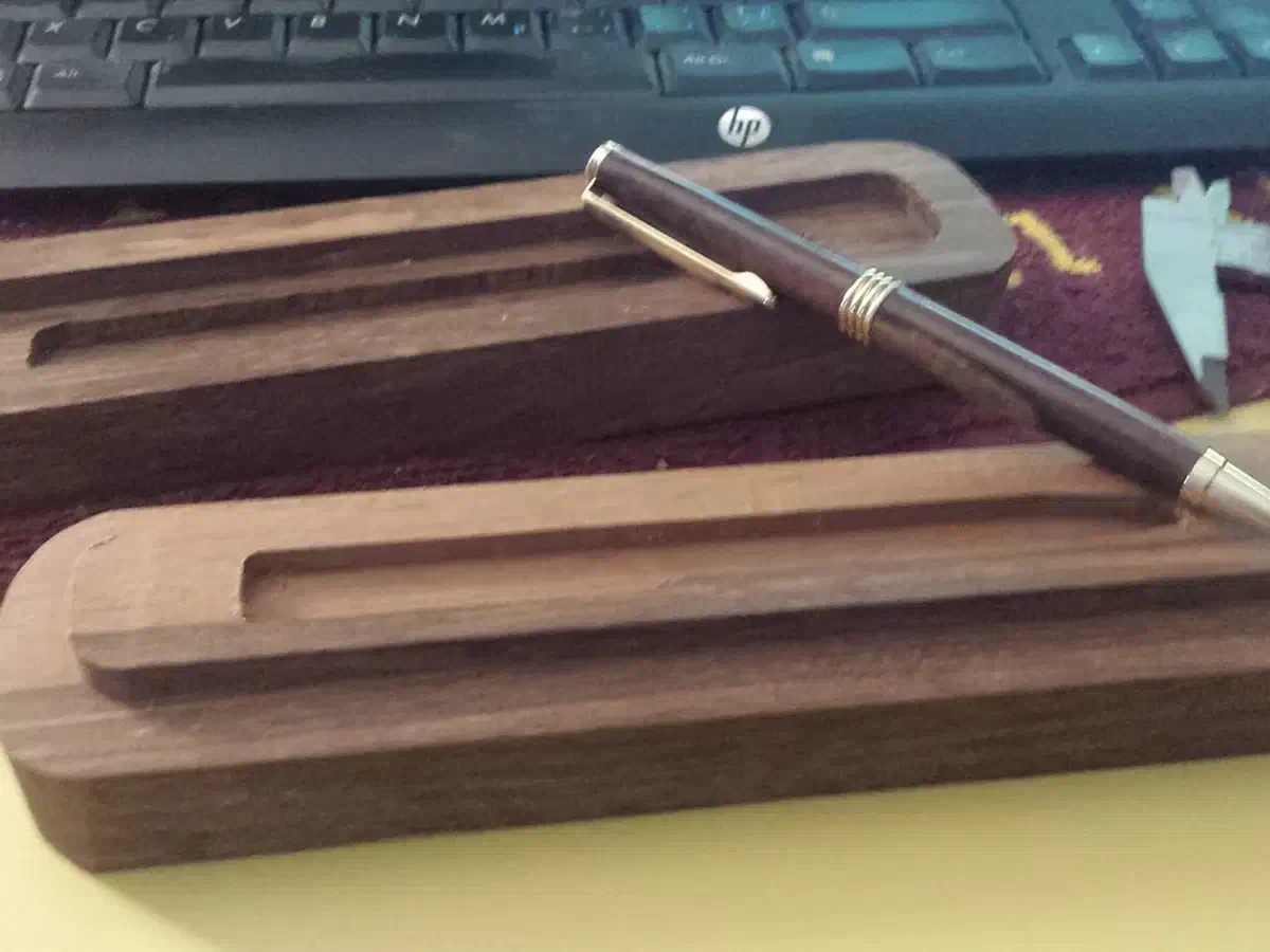 Finished fitted-lid wooden pen box displayed open with a pen inside