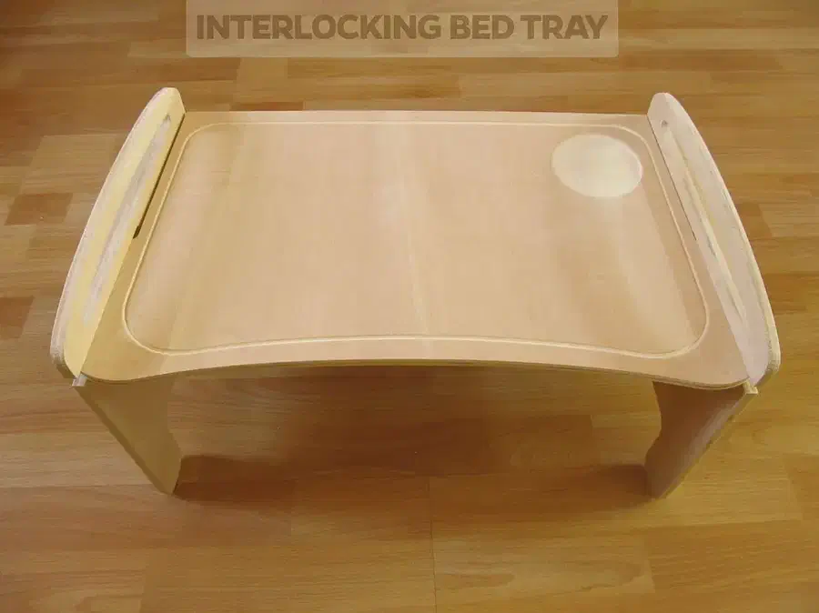 A pale plywood bed tray with handles along its raised side supports and a circular recess in the top