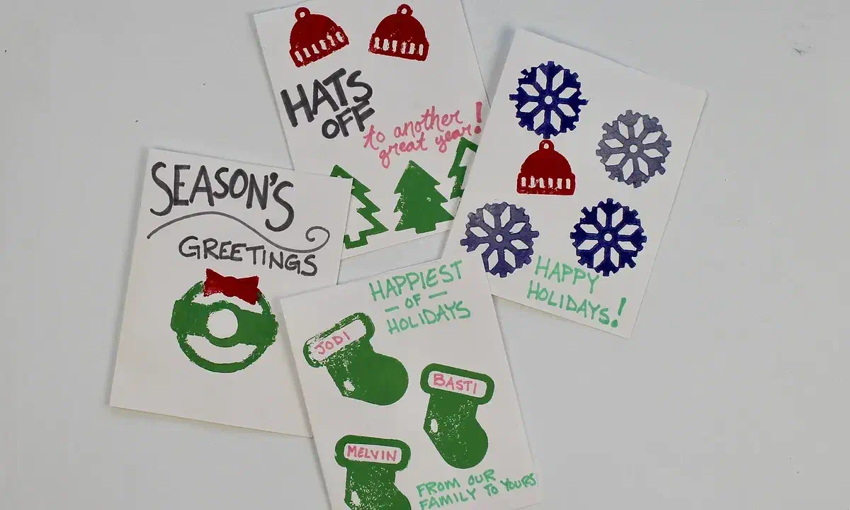 Hand-stamped holiday cards with colorful hats, mittens, snowflakes and greeting text
